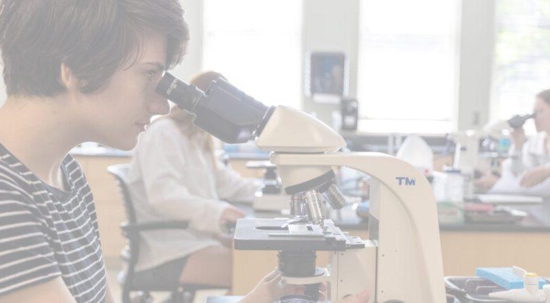 Female student looking into microscope