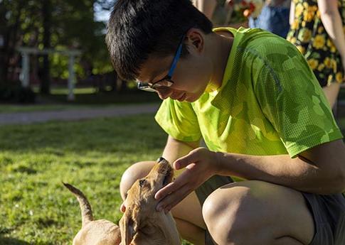 Student petting a small dog