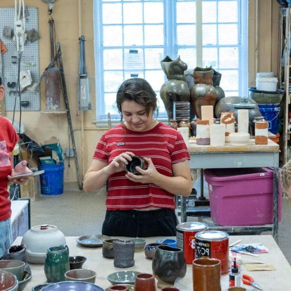 Student working with pottery